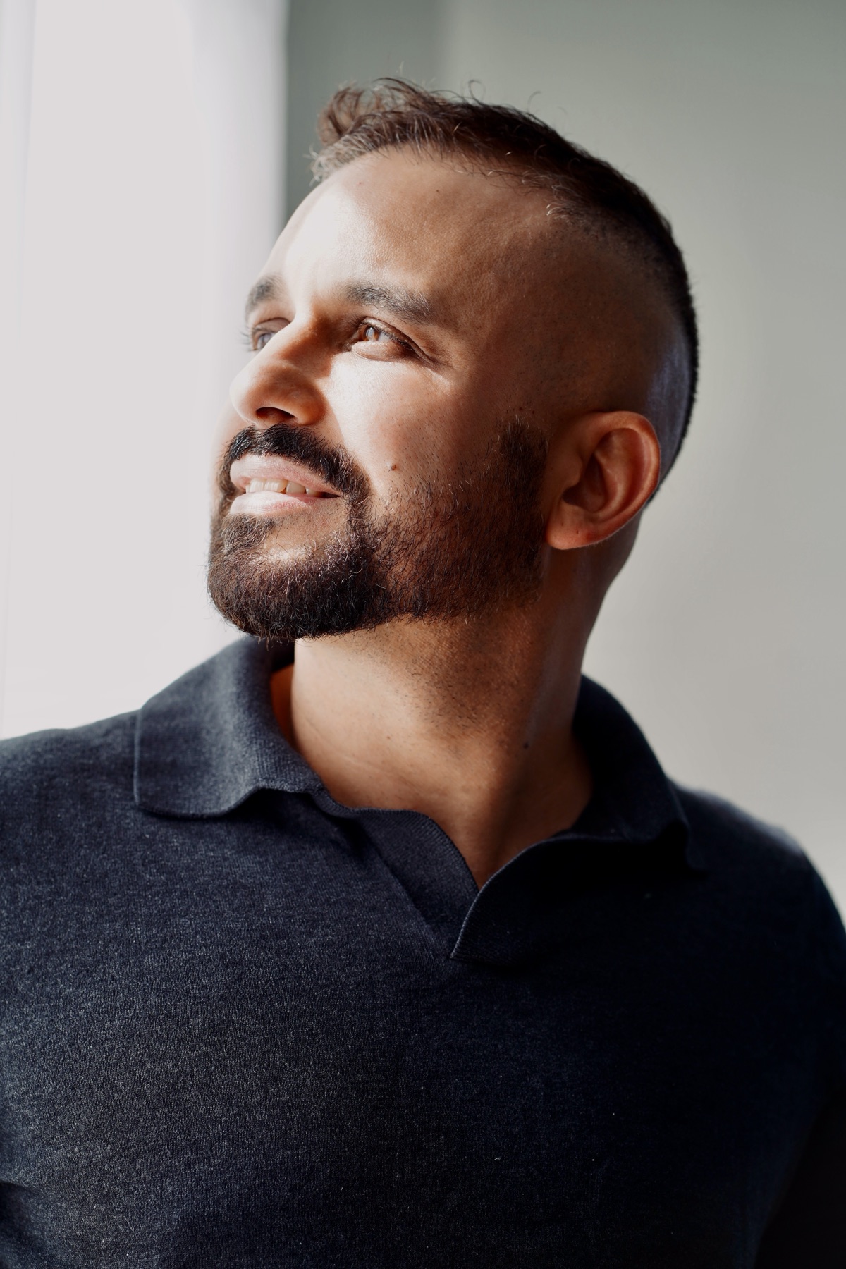 Portrait of Leo in a dark collared shirt, side light